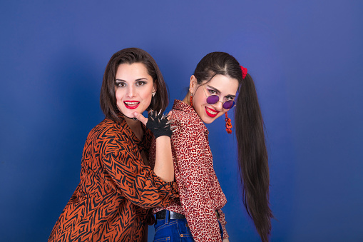 Party in retro 90s style. Two young women on blue background.