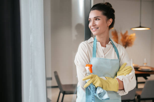 istock Smiling housewife in apron standing in the kitchen 1364638535