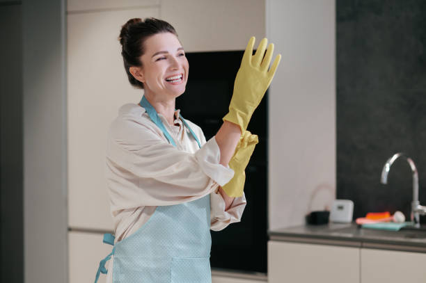 istock Young dark-haired woman cleaning in the kitchen 1364638562