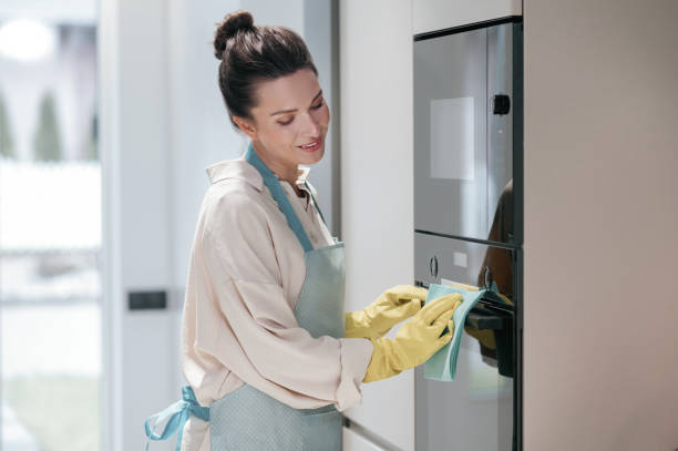 istock Young dark-haired woman cleaning in the kitchen 1364638565
