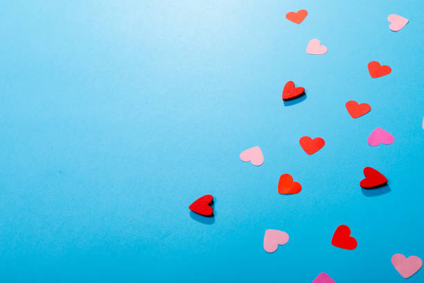 istock High angle view of red and pink hearts isolated on blue background, copy space 1364639652
