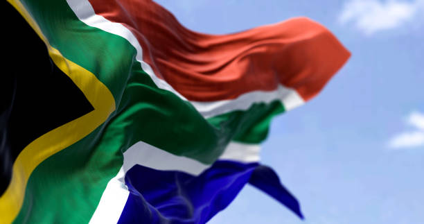 detailed close up of the national flag of south africa waving in the wind on a clear day - zuid afrika stockfoto's en -beelden