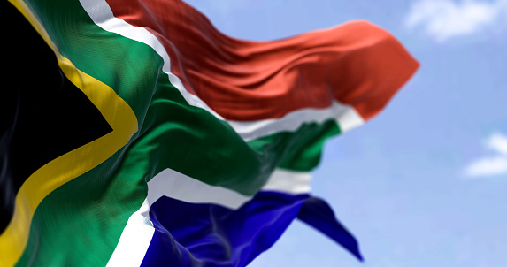 Detailed close up of the national flag of South Africa waving in the wind on a clear day. Democracy and politics. African country. Selective focus.