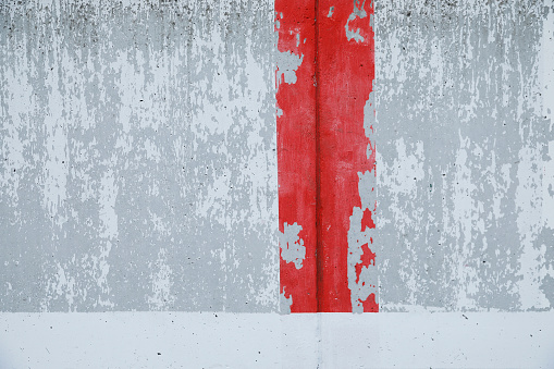 cracked white cement wall with red painted graffiti, surface peeled, background for text, no person
