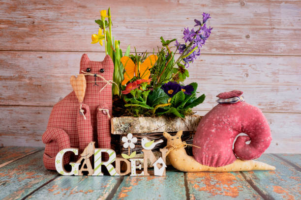 Pretty arrangement of different spring flowers with decoration on a wooden table.