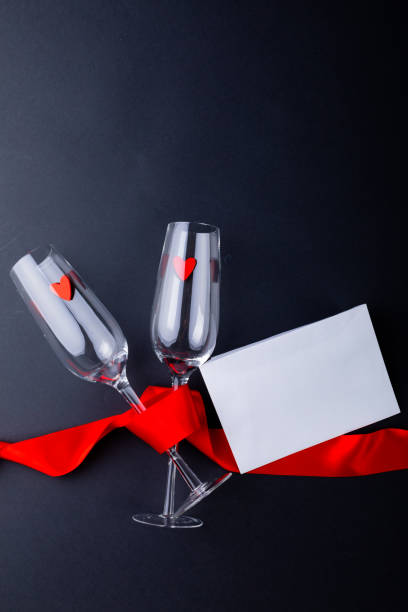 istock Empty champagne flutes tied with red ribbon by envelope isolated on gray background, copy space 1364642261