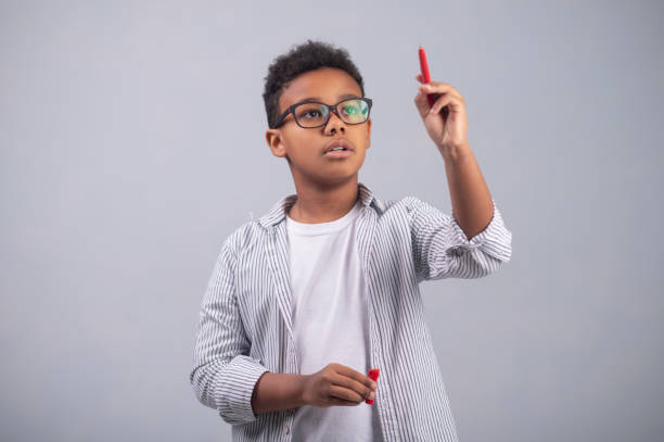 istock Cute boy in eyeglasses concentrated on his thoughts 1364643345