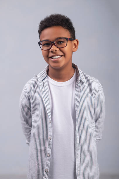 istock Cheerful kid in stylish spectacles standing against the white background 1364643357
