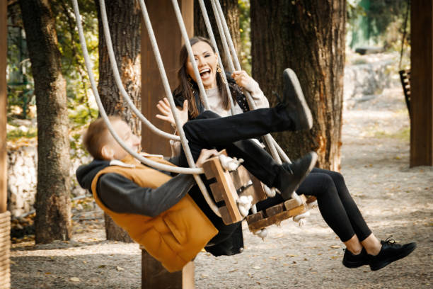 istock A young man on a date in the park rolled over on a swing. A fun date. 1364643599
