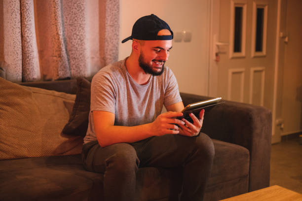 istock Young bearded happy man using his tablet while casually working from home in the evening 1364643894