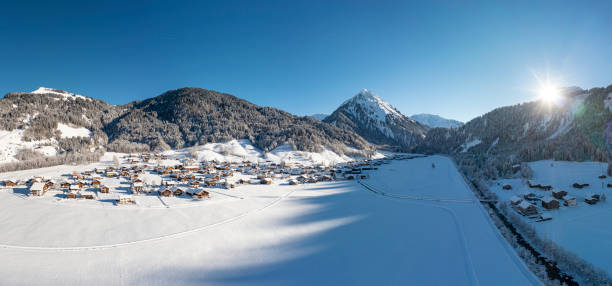 vue aérienne d’un village enneigé dans les montagnes - ski resort austria village winter photos et images de collection