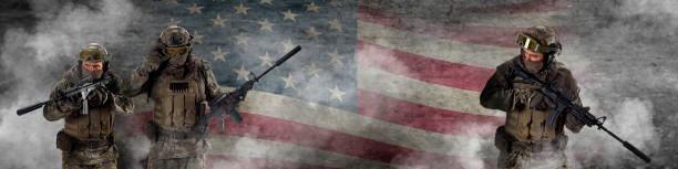 istock Three professional special forces soldiers, during a special operation is shrouded, in smoke against a US flag background. Defending flag. Photo format 4x1 1364647423