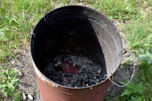 istock Burnt trash can on the grass in summer 1364648057