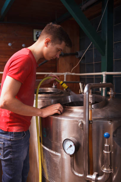 istock Young male brewer working at craft beer production 1364649216
