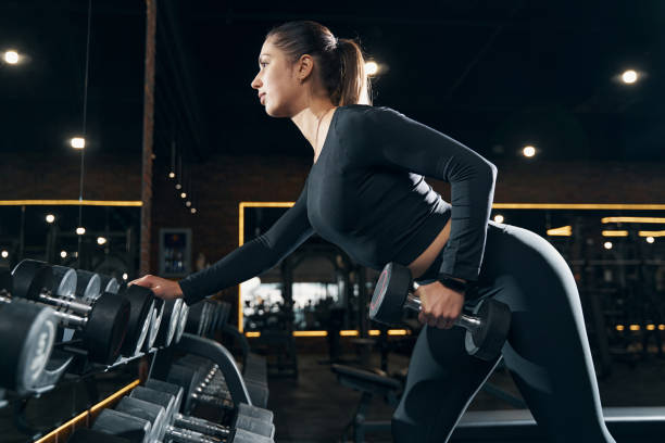 istock Female athlete performing standing single-arm bent-over row 1364650301
