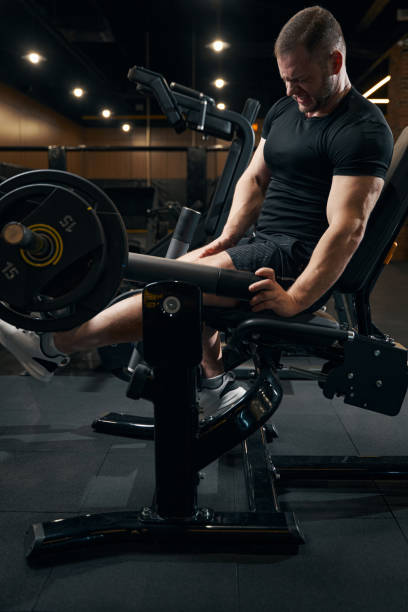 istock Bodybuilder doing strength training exercise on fitness equipment 1364650342