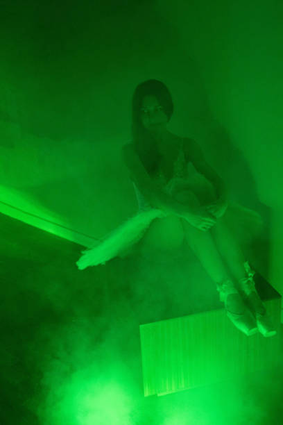 istock Ballerina with long legs posing in green light 1364650690