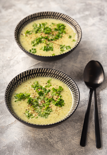 Homemade broccoli cream soup on light background.