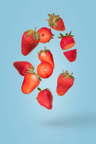 istock Creative composition with floating levitating ripe strawberries on a blue background. Vitamins, fresh healthy food concept 1364651361