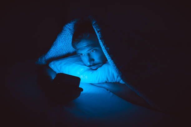istock Young man lying in bed and using smartphone before sleep. Social media addiction and insomnia 1364652921