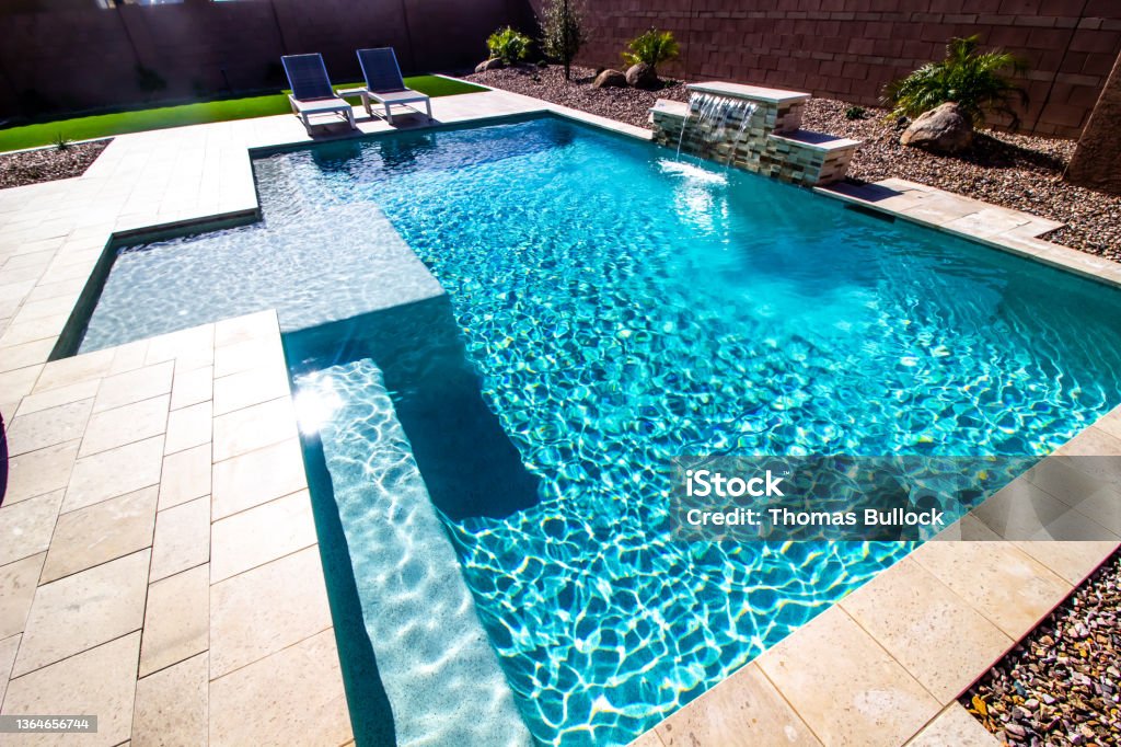 Back Yard With Two Lounge Chairs And Swimming Pool Back Yard With Two Lounge Recliner Chairs And Swimming Pool With Waterfall Swimming Pool Stock Photo