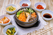 pibimbap korean cuisine on black bowl with spices on wooden table