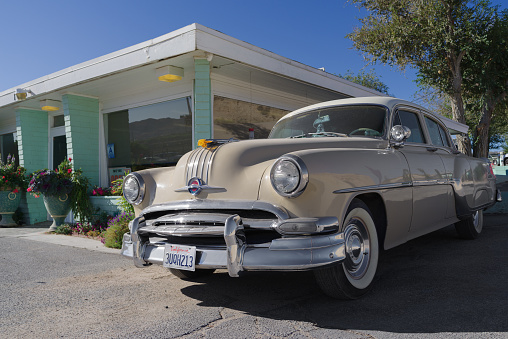 Victorville, California, USA: image of an early 50s Pontiac automobile shown parked by the historic diner Holland Burger Cafe.