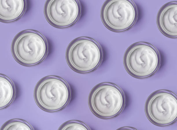 pattern of white cream jar on violet blue background close-up. beauty cosmetics presentation. top view - moisturizer cosmetics beauty treatment jar imagens e fotografias de stock