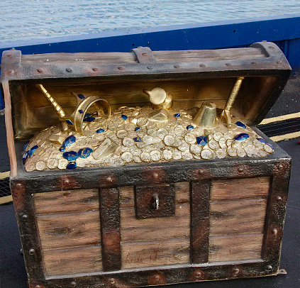 An old wooden and iron treasure chest on the beach