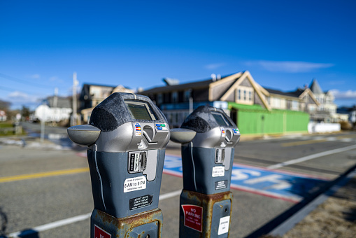 Tandem parking meters on the beach on Falmouth, MA during the winter months patiently waiting for customers!