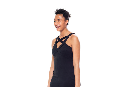 Side view of aged 20-29 years old who is beautiful african ethnicity female standing in front of white background wearing dress who is happy with hand by side
