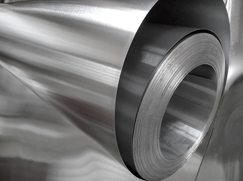roll of aluminum metal in industrial space. thin and shiny metal