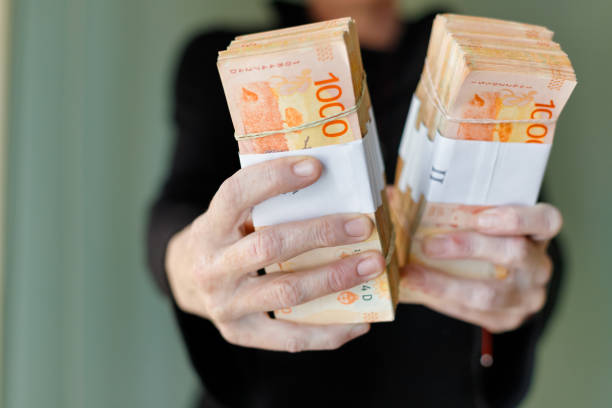 Macro closeup of bundles of 1000 Argentine peso bills held by woman's hands stock photo