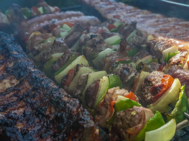 Close-up view of a grill with a variety of charcoal-cooked meats.