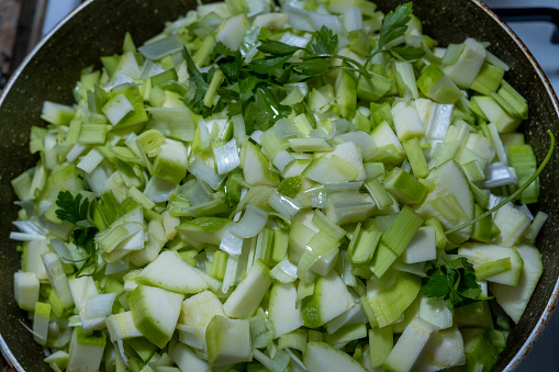 chopped zucchini, leek, onion and parsley prepared for cooking healthy vegetable dinner