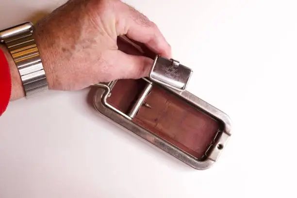 Razor blade, razor, sharpener held by a hand on a white background