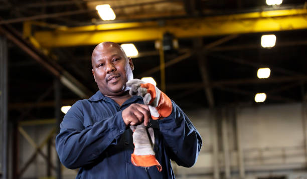 istock African-American man in warehouse putting on work gloves 1364681916