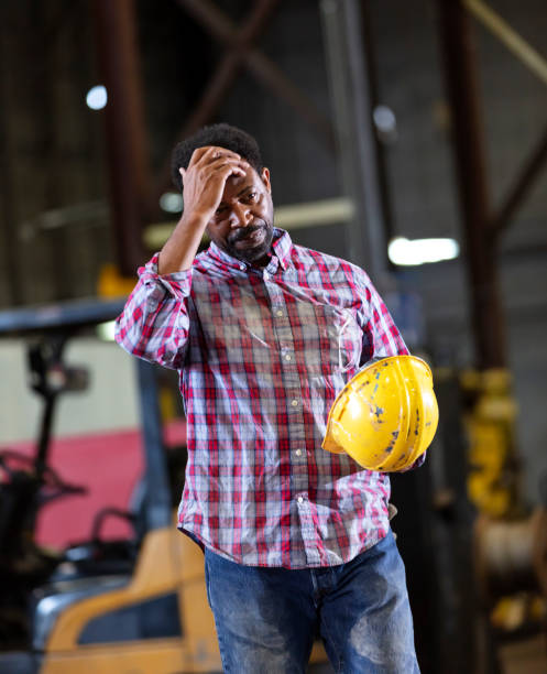 istock African-American man in warehouse holding hardhat 1364682212
