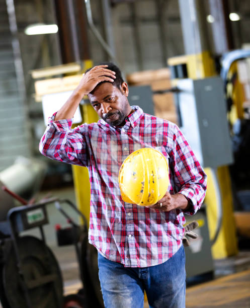 istock African-American man in warehouse holding hardhat 1364682247