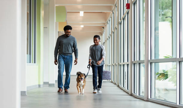 istock Boy and father walking dog down pet shelter hallway 1364683671