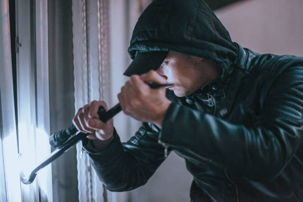 istock Intruder with flashlight before burglary into the house 1364683890