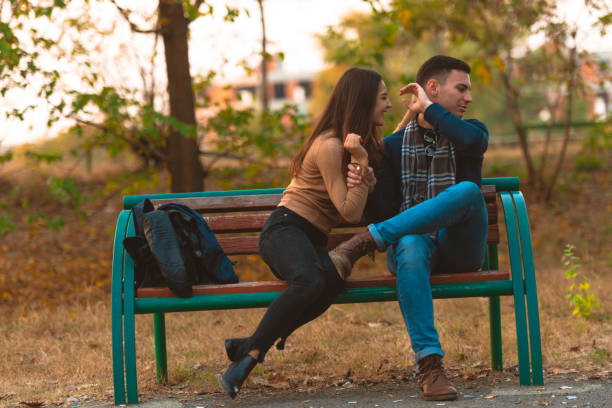 istock Angry boyfriend refusing to talk to his beautiful girlfriend while sitting in a park. 1364685472