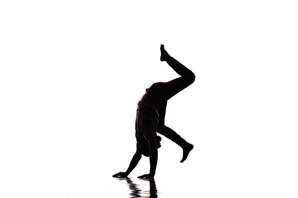 An urban guy is doing handstand in the studio while dancing modern dance