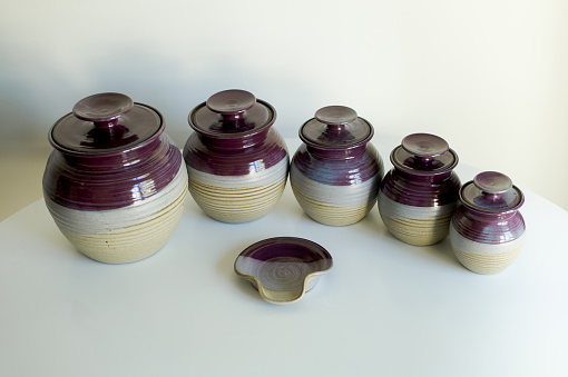Set of 5 lidded handmade glazed pottery jars with spoon rest