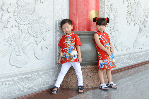 Little Asian boy and girl in Chinese traditional dress to celebrate Chinese New Year.