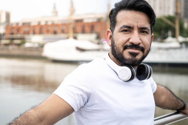 istock Latin man with beard, looking at camera with port environment behind him 1364697106