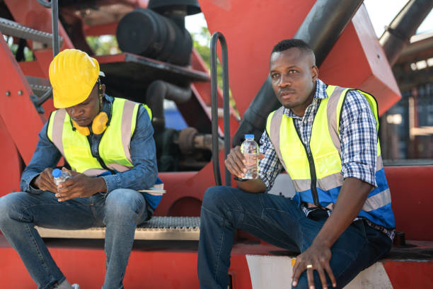 istock African workers, Engineer, Technician sitting and drinking water. people resting after working at the heavy machine vehicle. Concept people operation in heavy industrial. 1364701460