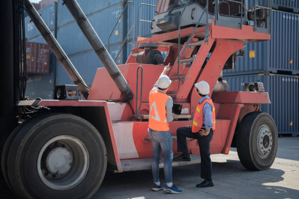 istock factory worker people men standing in front of containers logistic in warehouse. workers inspecting and meeting in front of heavy machine vehicle car. 1364703106