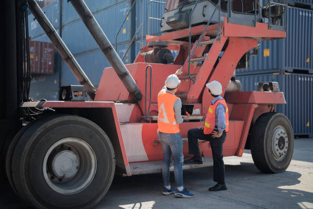 istock factory worker people men standing in front of containers logistic in warehouse. workers inspecting and meeting in front of heavy machine vehicle car. 1364703117