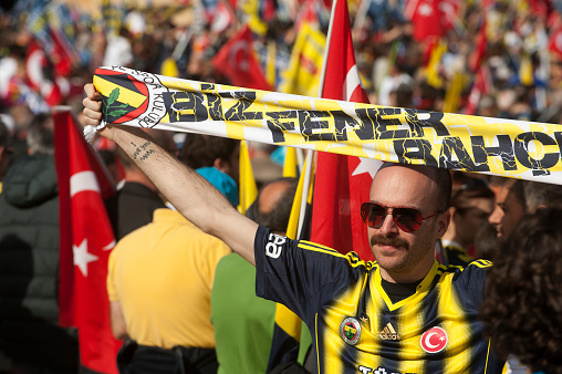 Hundreds of thousands of Fenerbahçe Sports Club supporters, holding Turkish and Fenerbahçe flags, chanted \
